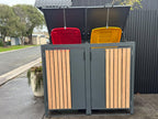 Two wheelie-bin covers outdoors with open top lids linked by chains to the red and yellow bin lids